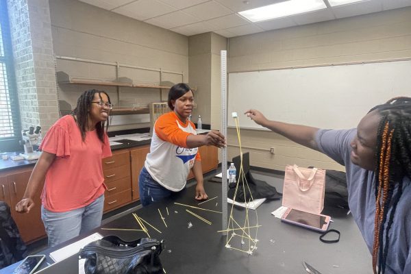 Left to right: Darfanda Mims-Scott, Antreshia Russell, and Charity Davis race to build the highest free-standing tower using only thin spaghetti noodles, marshmallows, and tape.