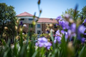 Outside view of Foundation residence hall, behind flowers.